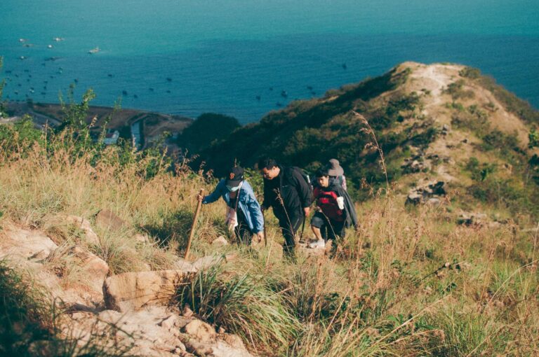 A group hiking on a sunny trail with ocean views in Nha Trang, Vietnam.