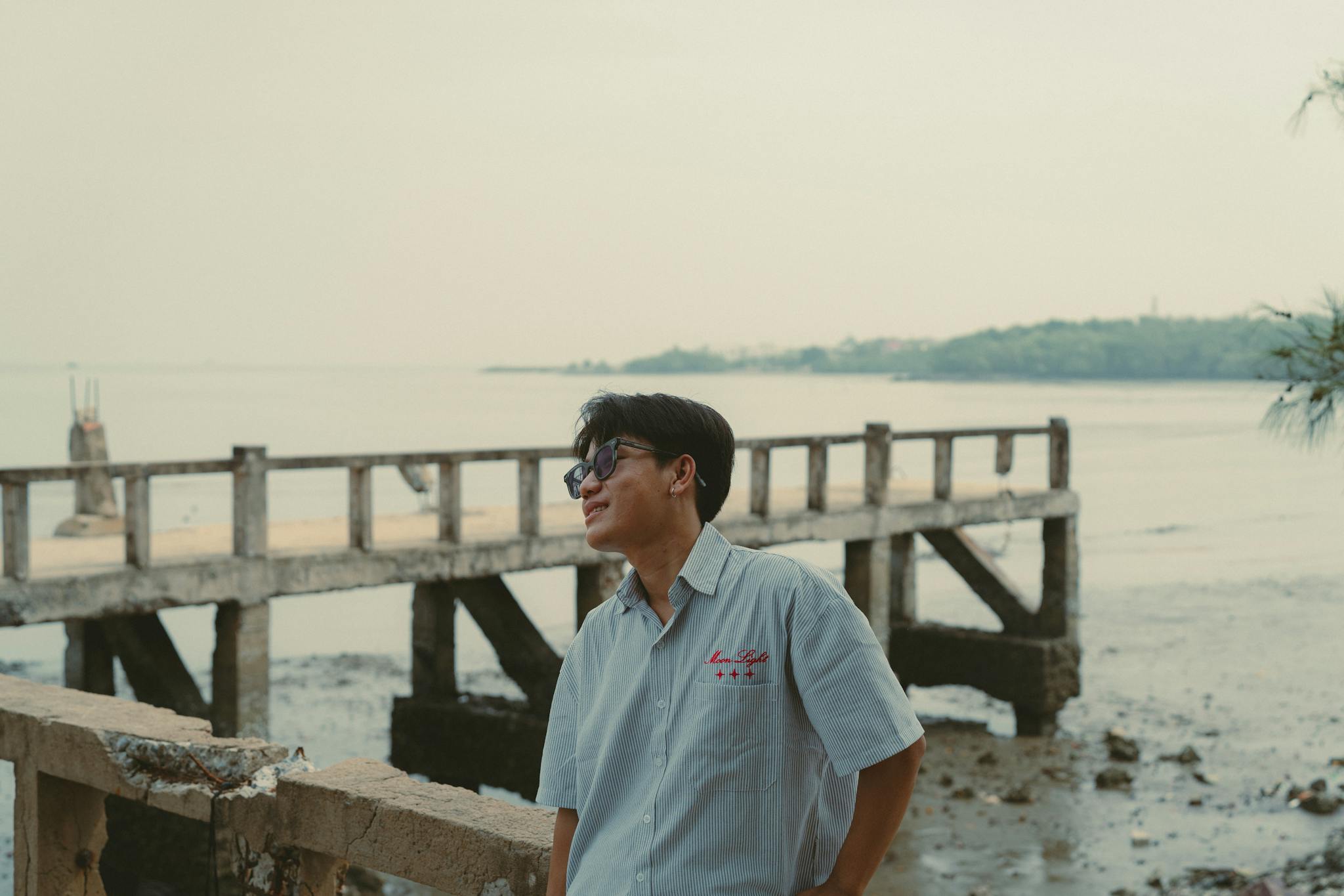 Casual portrait of a man enjoying the view by the pier in Ho Chi Minh City, Vietnam.